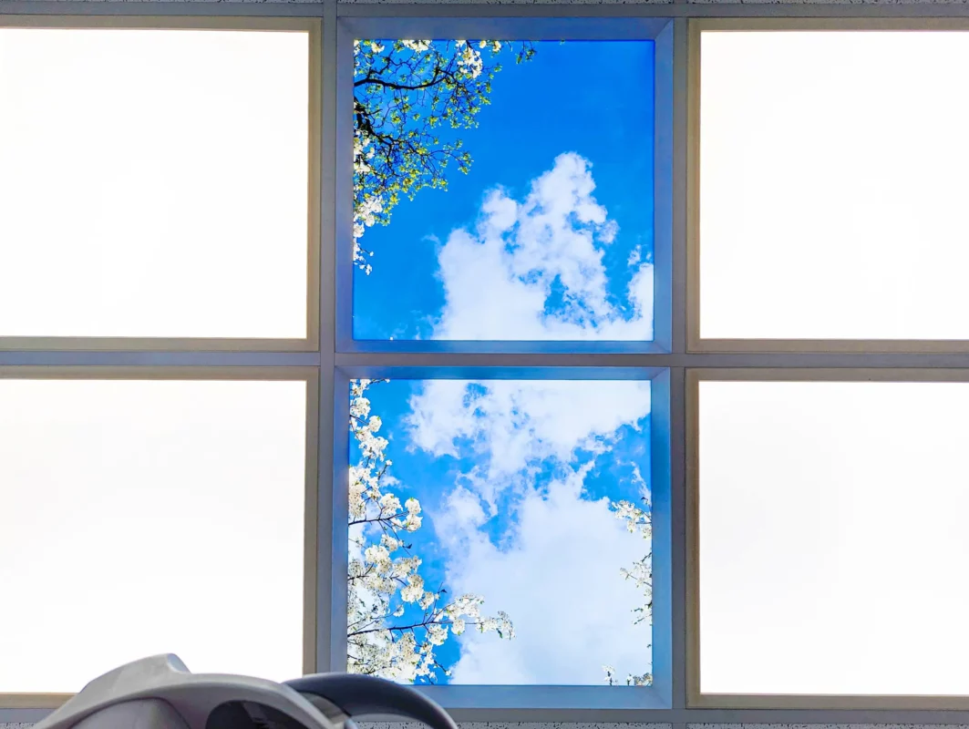 Contemporary dental treatment room with bright DL62 daylight panels and soothing nature photo ceiling at Zahnarztpraxis Dr. Grünewald.