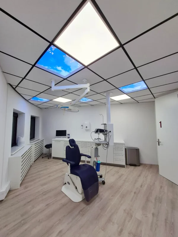 Dentled ceiling panels installed in OraMax Clinics Breda treatment rooms for a calming atmosphere.