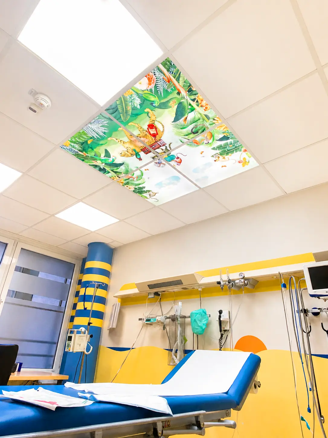 Dentled LED photo panels featuring nature imagery integrated into the ceiling of a pediatric healthcare facility.