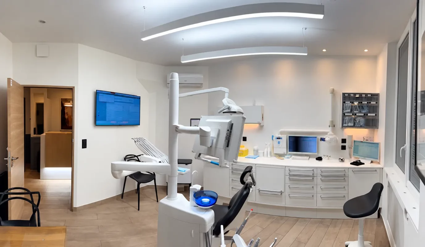 Wide view of Dr Didier Achour’s dental treatment room in Paris, showing suspended lighting and the treatment unit.